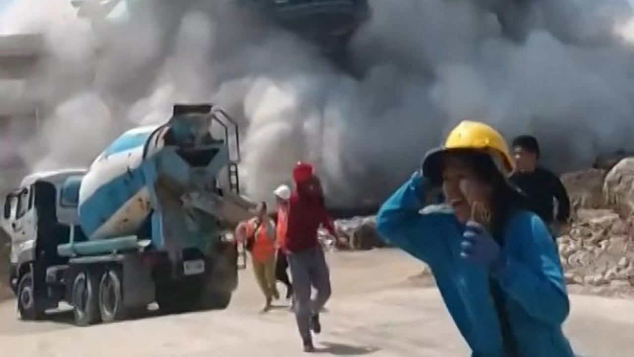 Esta captura de fotograma de un video de UGC tomado y publicado por Khon Su Cheevit Adeet Mai Suay Rok Na en Facebook, el 28 de marzo de 2025, muestra a los trabajadores huyendo de un edificio mientras se derrumba en un sitio de construcción en Bangkok, luego de un terremoto (Foto de Handout / Cortesía del usuario de Facebook Khon Su Cheevit Adeet Mai Suay Rok Na / AFP).