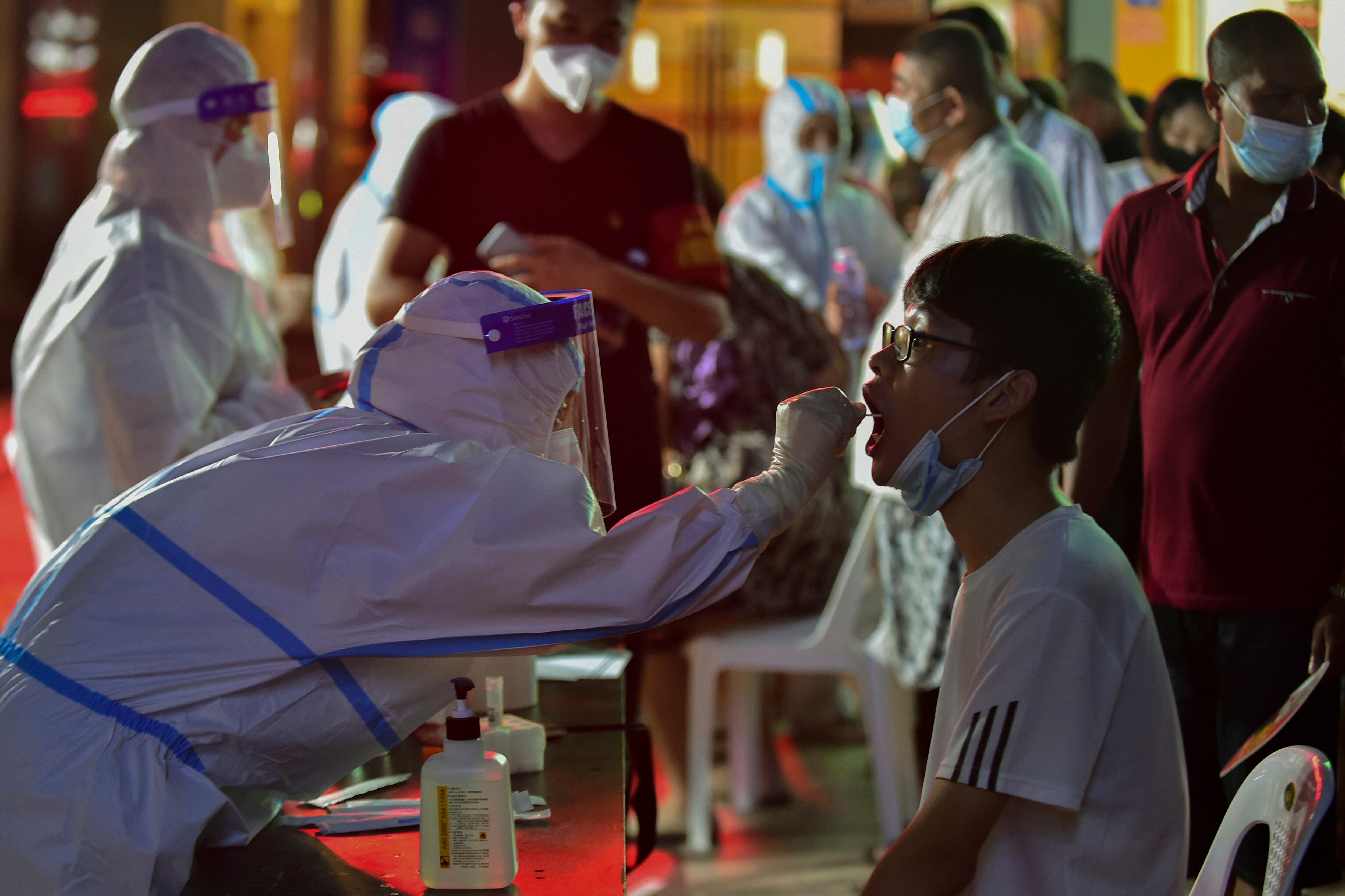 En esta foto publicada por la Agencia de Noticias Xinhua, un trabajador de la salud toma una muestra de hisopo de un residente durante una prueba masiva de COVID-19 en Putian, en la provincia de Fujian, en el sureste de China, el domingo 2 de septiembre. (Wei Peiquan/Xinhua via AP)