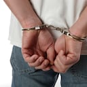 Man in handcuffs behind his back.