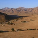 In the region of Sous Massa, near Tata, in south-eastern Morocco, stretches a desert plain of the Sahara Desert, near the Anti-Atlas mountain range at the foot of Jebel Bani. The desert advances little by little and sand dunes sometimes cover the palm trees of the great oasis.