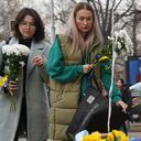Women arrive to lay flowers with ribbons in the colors of the Ukrainian national flag at the statue of Taras Shevchenko, also known as Kobzar, a Ukrainian poet, writer, artist, public and political figure, to mark the first anniversary of Russia's full-scale invasion of Ukraine in Almaty, Kazakhstan, Friday, Feb. 24, 2023. ((Vladimir Tretyakov/NUR.KZ via AP)