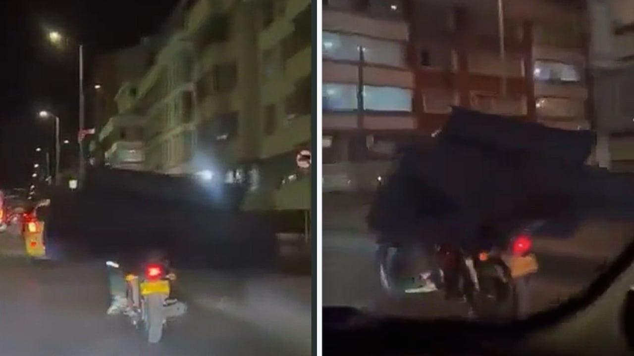 Imagen de motociclista trasteando un gran sofá en moto.