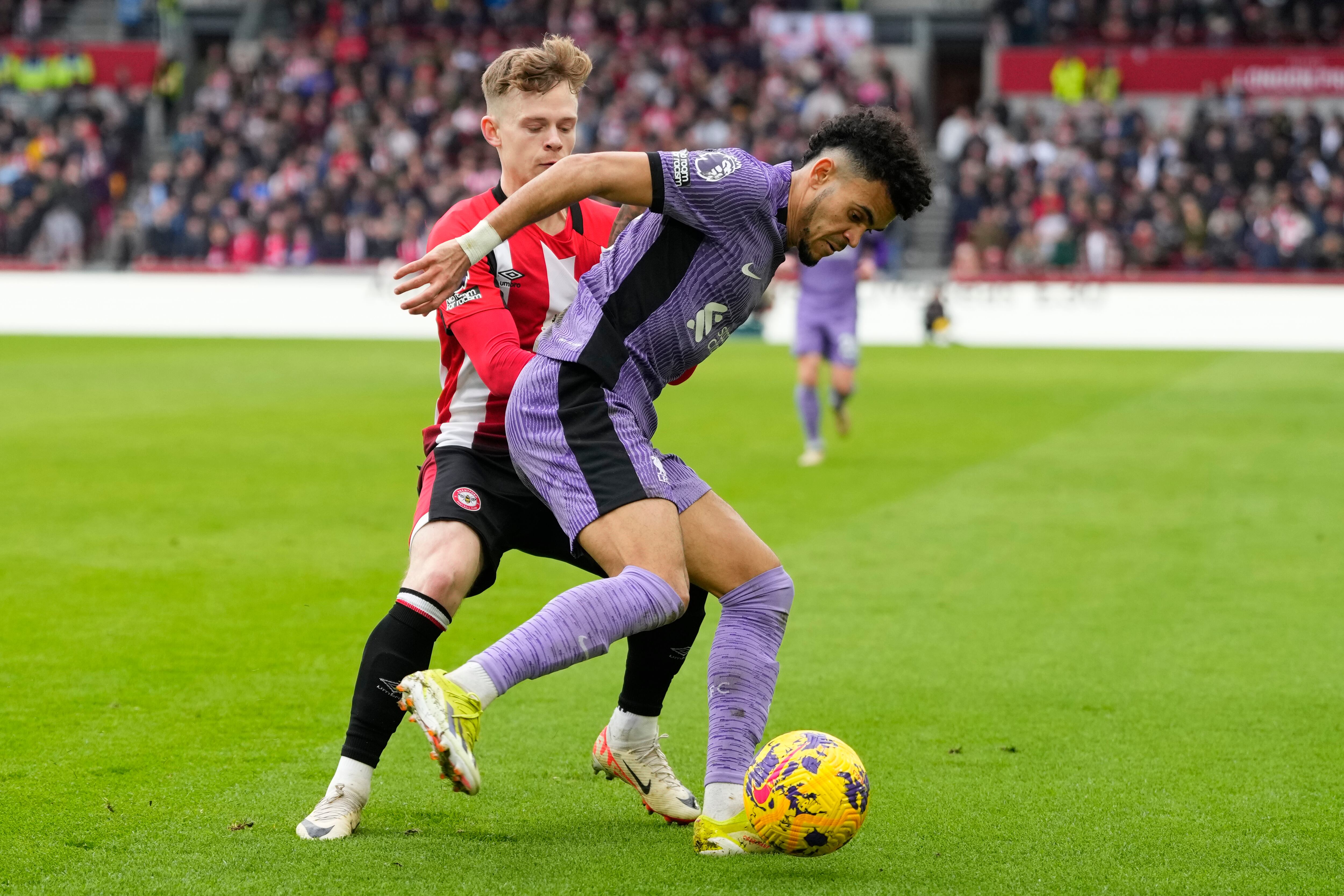 Luis Díaz del Liverpool compite por el balón con Keane Lewis-Potter del Brentford durante el partido de fútbol de la Liga Premier inglesa entre Brentford y Liverpool en el Gtech Community Stadium de Londres, el sábado 17 de febrero de 2024. (Foto AP/Kirsty Wigglesworth)