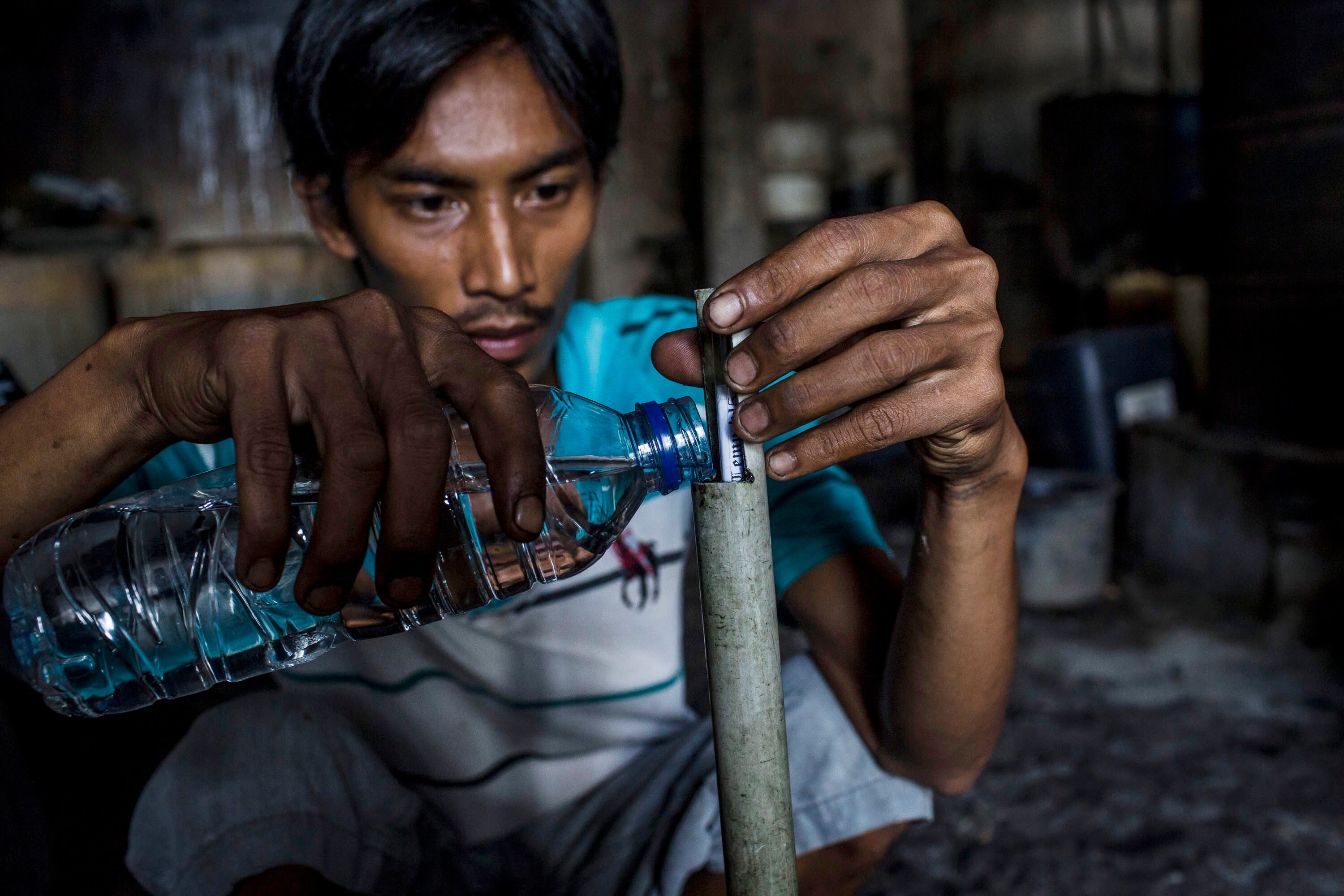 n trabajador mide el nivel porcentual de ciu, un alcohol producido a partir de la fermentación de la caña de azúcar, utilizando un alcoholímetro durante el proceso de destilación de alcohol etanol en la aldea de Bekonang el 9 de febrero de 2016 en Sukoharjo, Java Central, Indonesia.