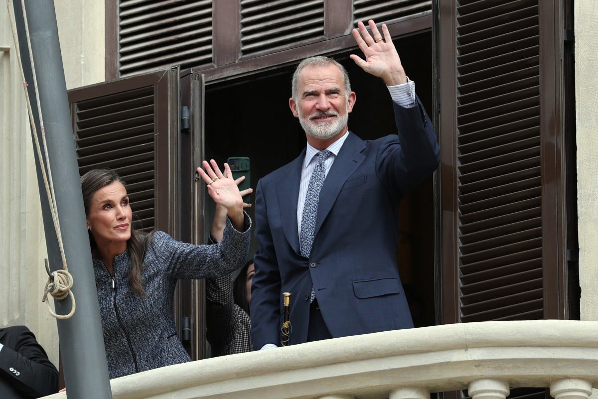 El rey Felipe VI de España (derecha) y la reina Letizia saludan desde el balcón del Ayuntamiento a su llegada al enclave español de Ceuta, en el norte de África, el 13 de octubre de 2026. Los reyes de España realizan hoy una visita diplomáticamente delicada a Ceuta para apoyar a una ciudad sumida en una crisis desde la oleada migratoria procedente de Marruecos ocurrida en julio. Su viaje supone la primera visita de la realeza desde 2007, año en que estalló una crisis diplomática con el vecino Marruecos, país que reclama la soberanía sobre Ceuta y sobre Melilla, el otro territorio español en el norte de África.