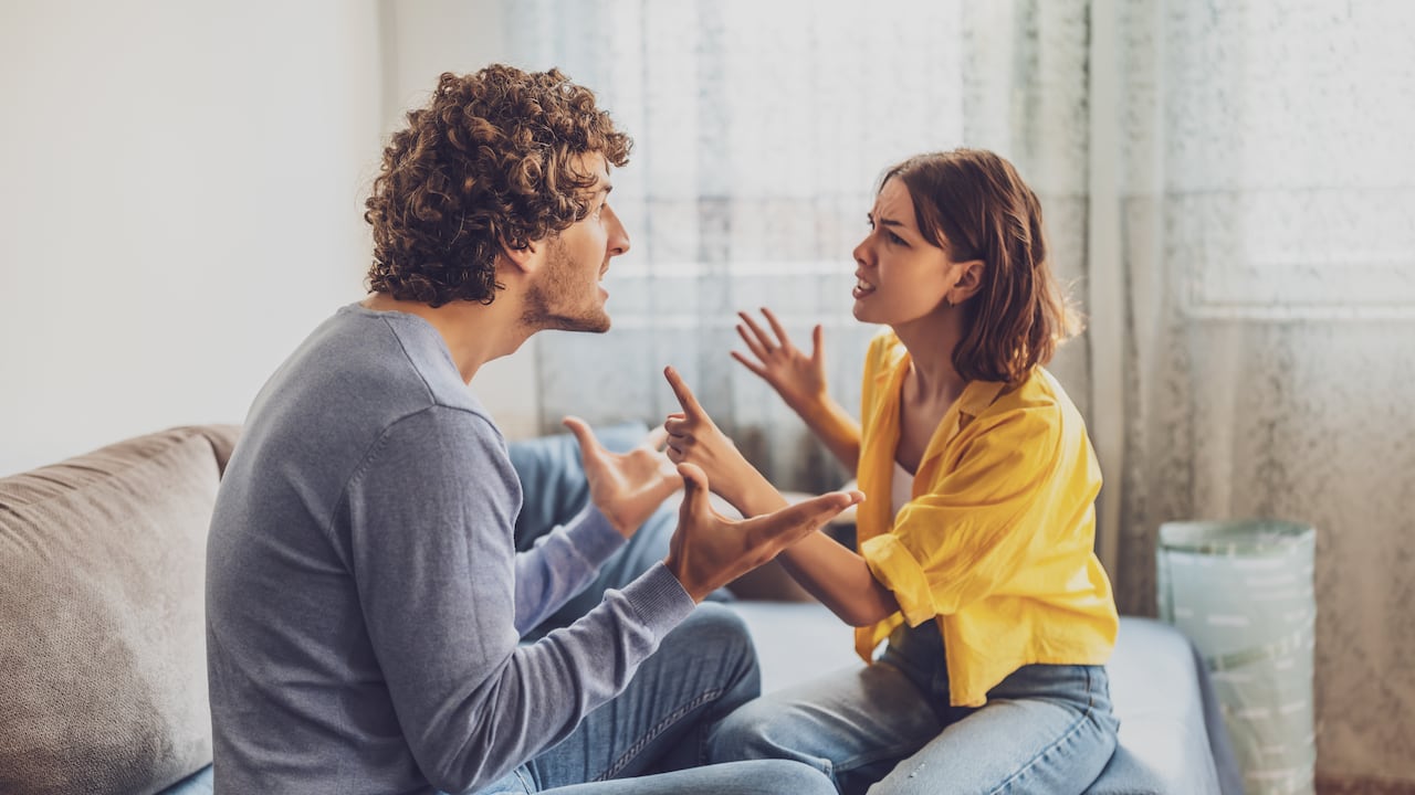El hombre y la mujer están sentados en el sofá y discutiendo. Problemas de relación.