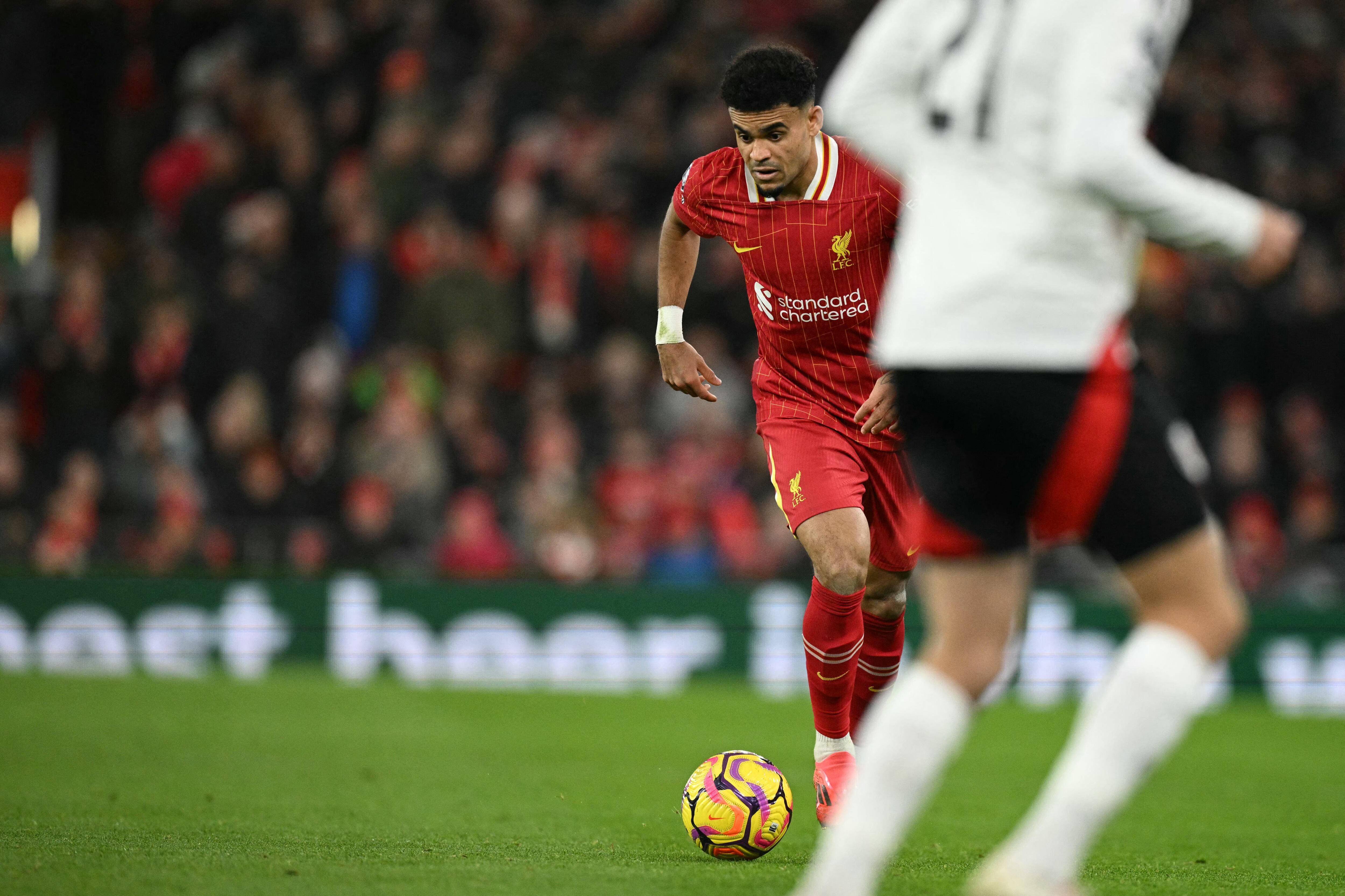 Liverpool's Colombian midfielder #07 Luis Diaz runs with the ball during the English Premier League football match between Liverpool and Fulham at Anfield in Liverpool, north west England on December 14, 2024. (Photo by Oli SCARFF / AFP) / RESTRICTED TO EDITORIAL USE. No use with unauthorized audio, video, data, fixture lists, club/league logos or 'live' services. Online in-match use limited to 120 images. An additional 40 images may be used in extra time. No video emulation. Social media in-match use limited to 120 images. An additional 40 images may be used in extra time. No use in betting publications, games or single club/league/player publications. /