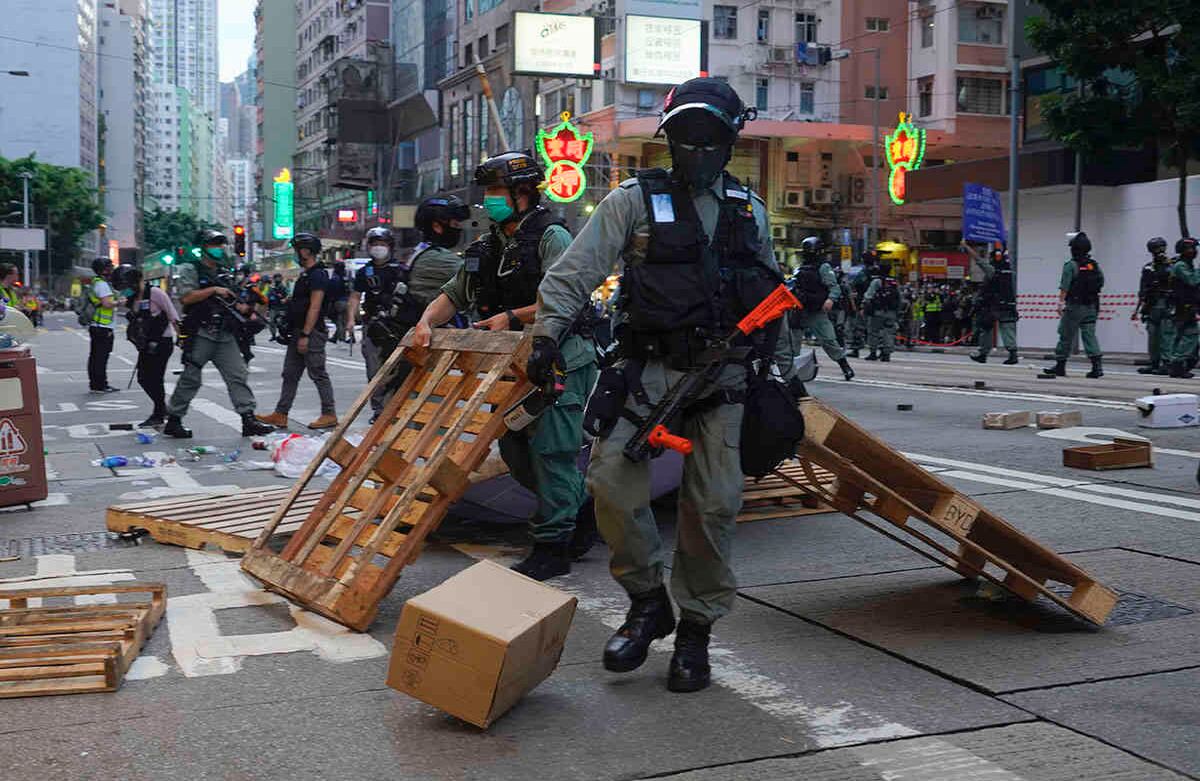 La policía quita un obstáculo en una vía principal de Hong Kong, el miércoles 1 de julio durante una marcha que marca el aniversario del traspaso de este territorio de Gran Bretaña a China. Hong Kong celebró el aniversario 23 de su entrega a China tan solo un día después de que el país promulgara una ley de seguridad nacional que toma medidas enérgicas contra las protestas en el territorio. Foto: Vincent Yu / AP