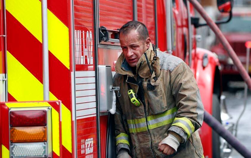 Un bombero, cansado, trabaja para apagar el incendio.
Foto León Darío Peláez