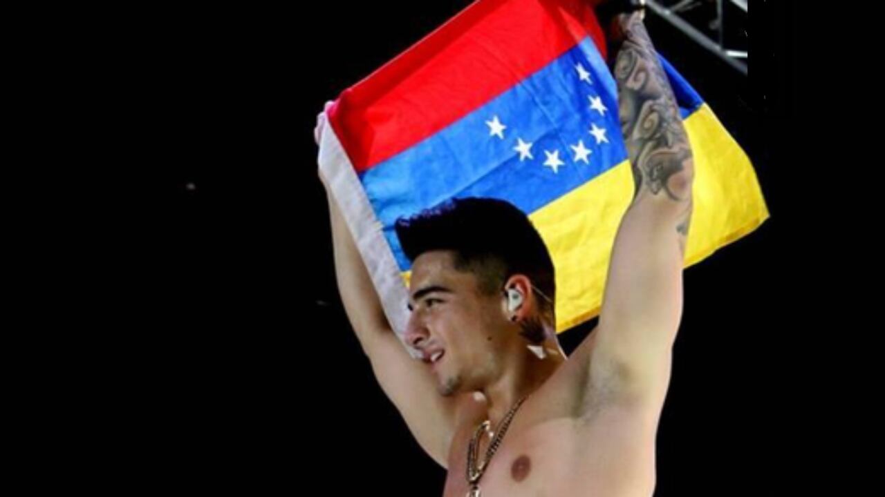 El cantante Maluma con una bandera, al revés, de Venezuela.