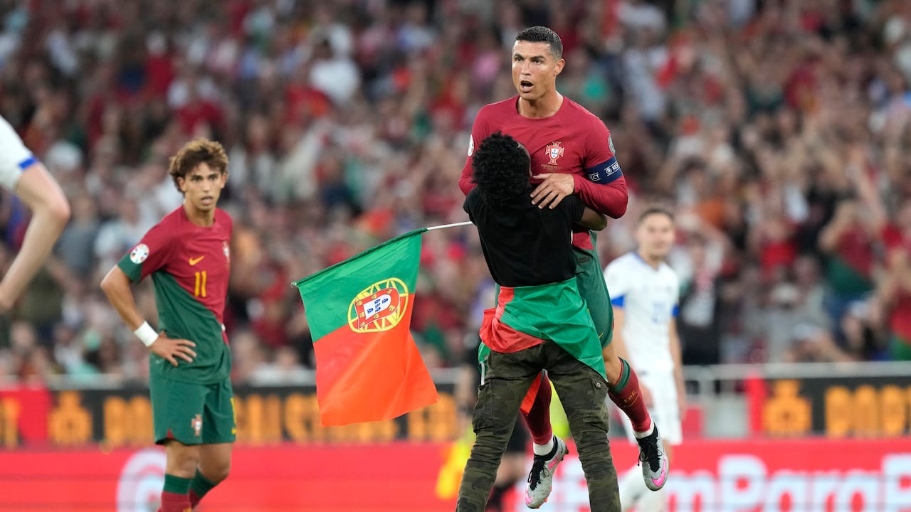 Un individuo que irrumpió en la cancha para abraza al astro portugués Cristiano Ronaldo durante el partido contra
Bosnia y Herzegovina por las eliminatorias de la Eurocopa.