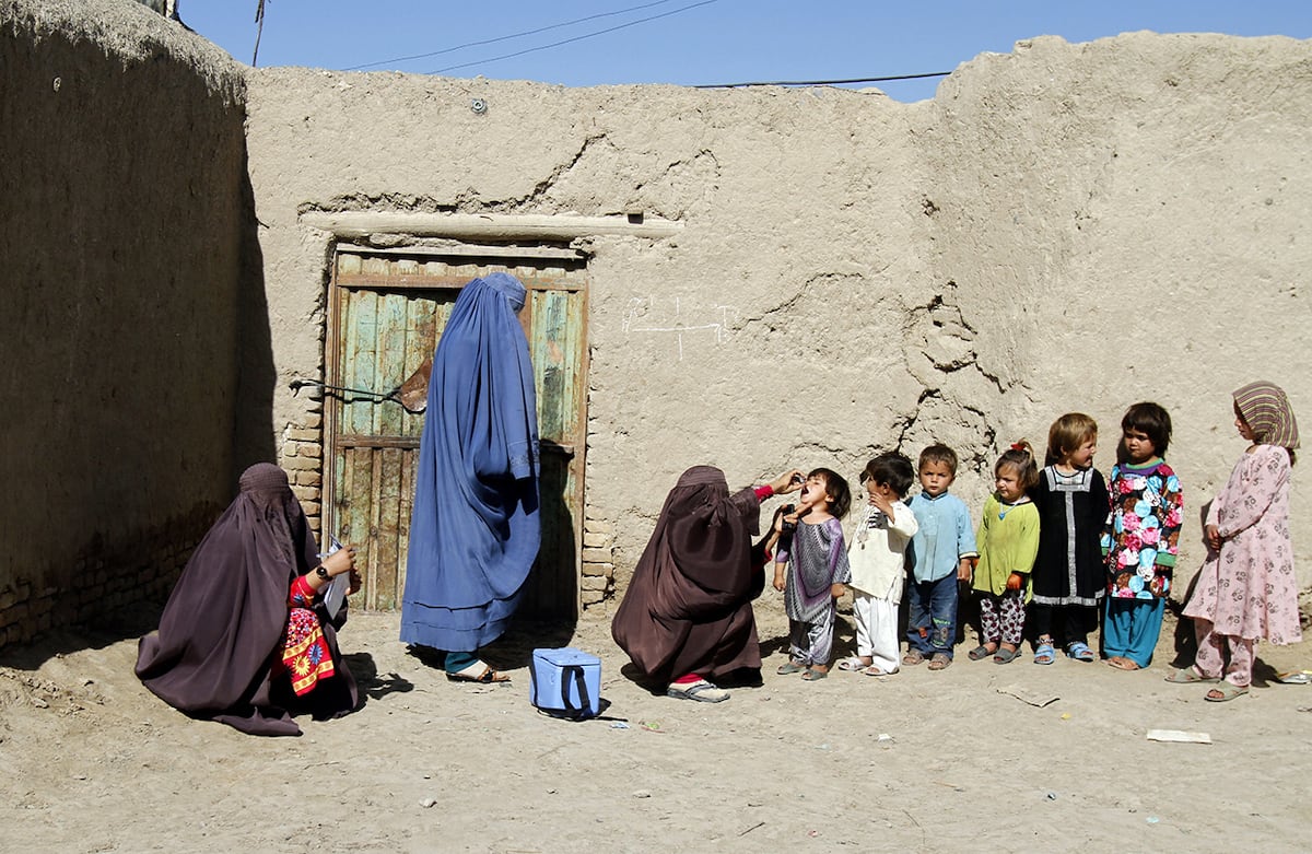 Una doctora afgana vacuna a los niños durante una campaña contra la polio en Kandahar, Afganistán. (AP)