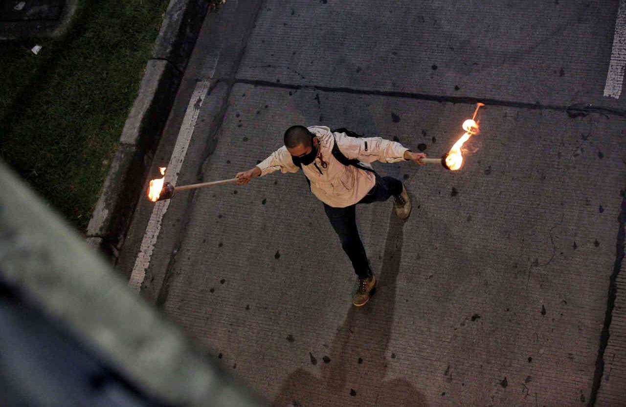 Hombre con antorchas en las dos manos protestando en cuarentena