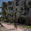 Un hombre pasa en bicicleta por una zona dañada por el huracán Otis, el domingo 29 de octubre de 2023, en Acapulco, México. (AP Foto/Félix Márquez)