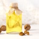 Aceite de nuez en botella sobre fondo blanco de madera. Enfoque selectivo. Aceite jojoba