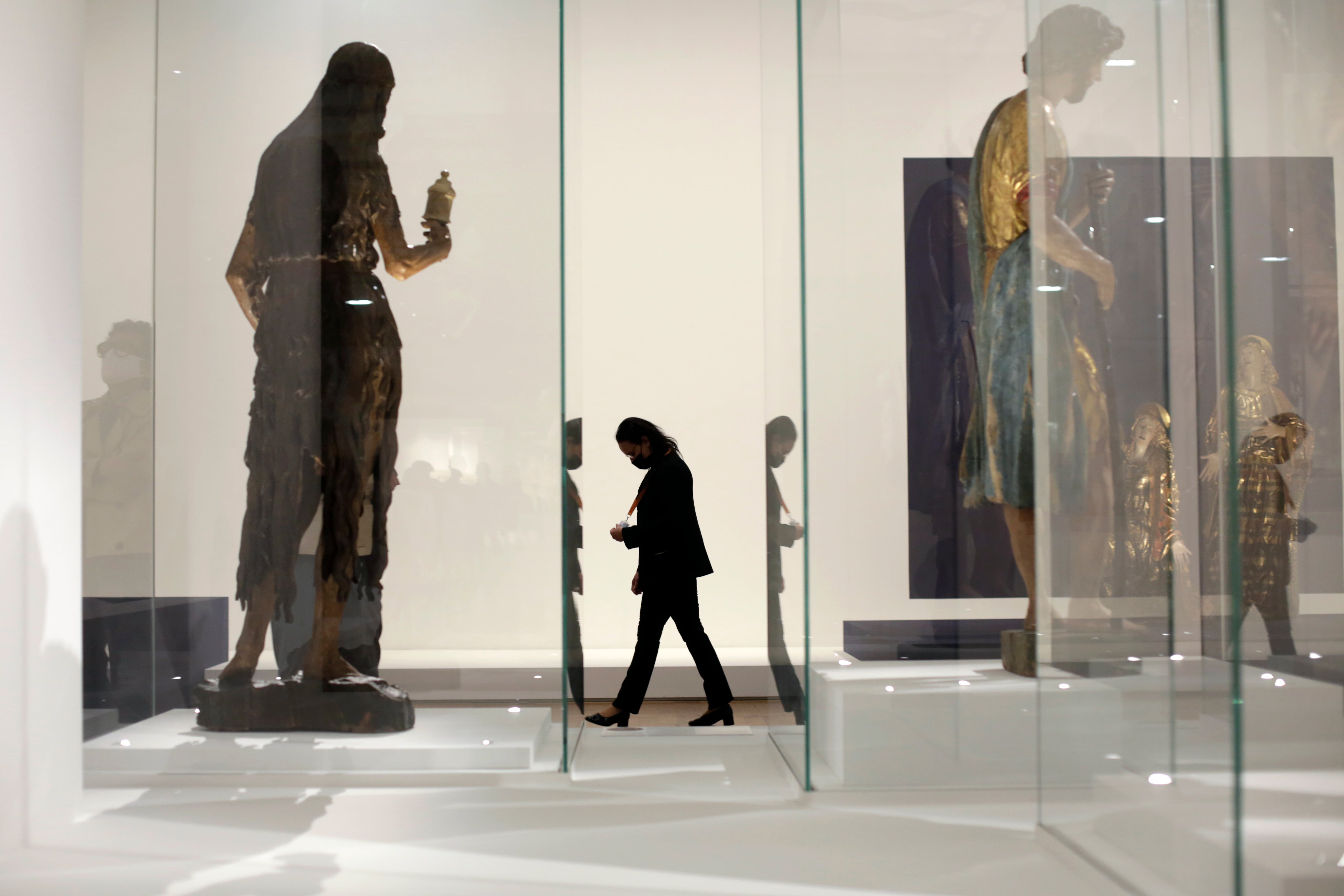 A museum worker walks inside the Louvre museum, Wednesday, May, 19, 2021 in Paris. Museums must restrict entries so there is 8 square meters of space (86 square feet) per visitor. Café and restaurant terraces are reopening Wednesday after a shutdown of more than six months deprived people of what feels like the essence of life — sipping coffee and wine with friends outdoors — to save lives during the coronavirus pandemic. (AP Photo/Thibault Camus)