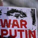A man holds a banner during a rally to mark the one-year anniversary of Russia's invasion of Ukraine in Belgrade, Serbia, Friday, Feb. 24, 2023. A traditional Slavic ally, Serbia has maintained friendly relations with Russia despite the invasion and has refused to join Western sanctions designed to punish Moscow for the aggression. (AP Photo/Darko Vojinovic)