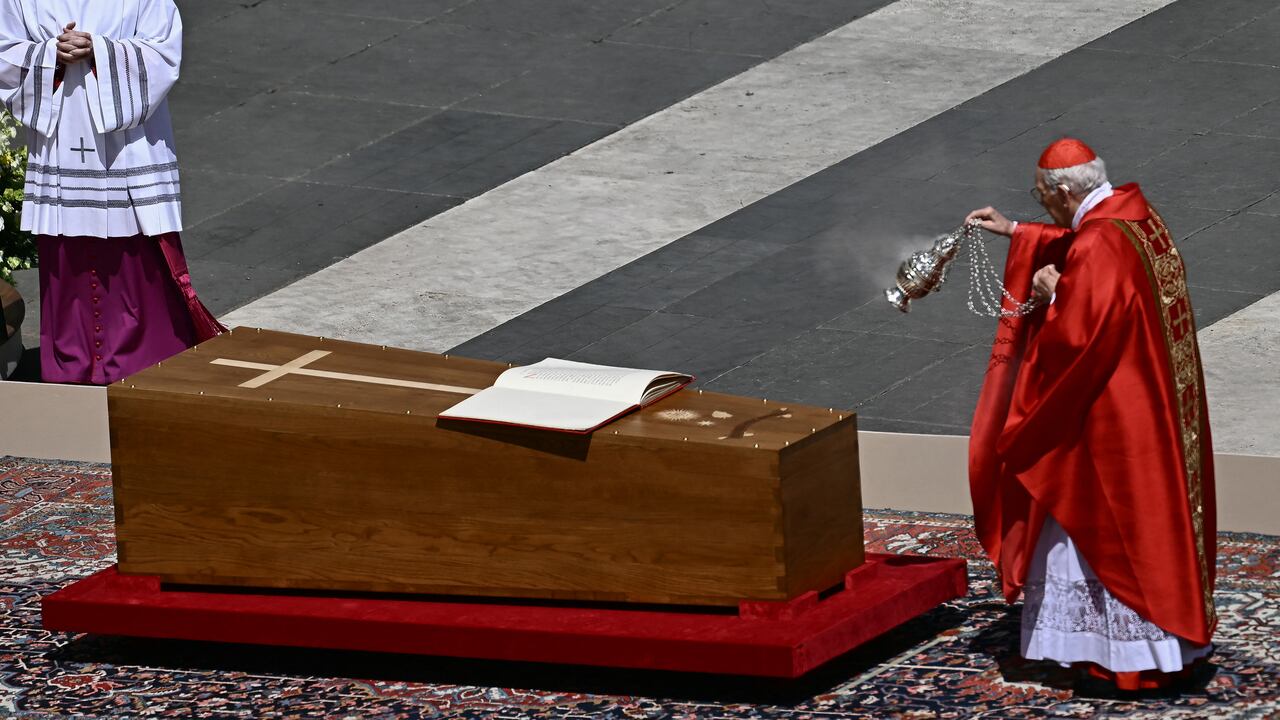 El cardenal italiano Giovanni Battista Re balancea un incensario hacia el ataúd del Papa Francisco, con el libro de los Evangelios expuesto, durante la ceremonia fúnebre en la Plaza de San Pedro del Vaticano, el 26 de abril de 2025.