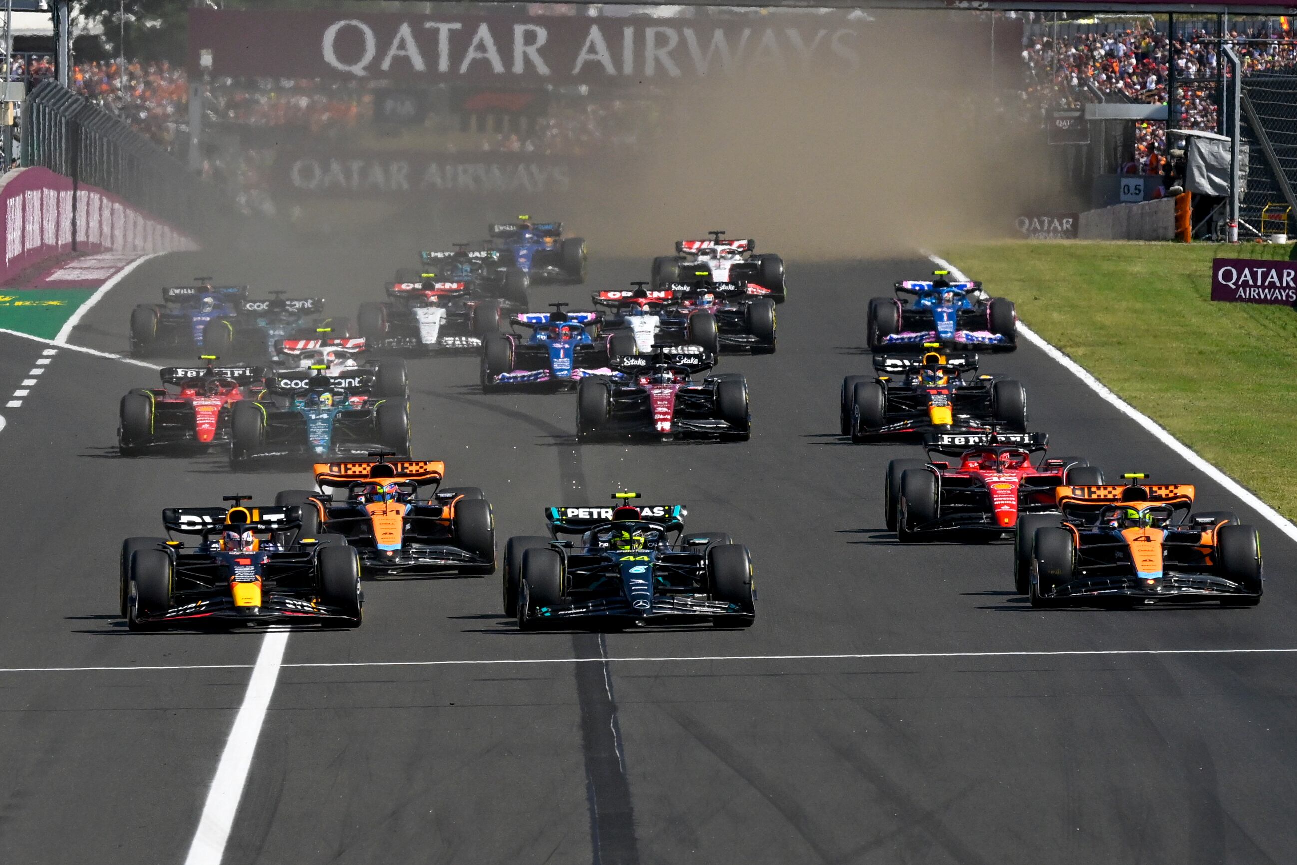 El piloto neerlandés de Fórmula Uno Max Verstappen de Red Bull Racing, a la izquierda, lidera en la largada seguido por el piloto británico de Fórmula Uno Lewis Hamilton de Mercedes-AMG Petronas durante la carrera automovilística del Gran Premio de Hungría de Fórmula Uno, en el circuito de Hungaroring en Mogyorod, cerca de Budapest, Hungría, el domingo 23 de julio de 2023. (Foto AP/Denes Erdos)