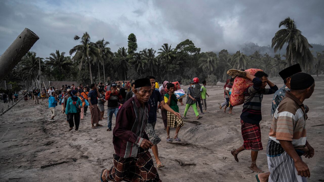 Los aldeanos rescatan sus pertenencias en un área cubierta de ceniza volcánica en Sumber (Photo by JUNI KRISWANTO / AFP)