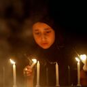 Una niña cachemira enciende las luces de las velas cerca a la tumba de su pariente, durante el Día de Expiación en Srinagar, India. (AP)