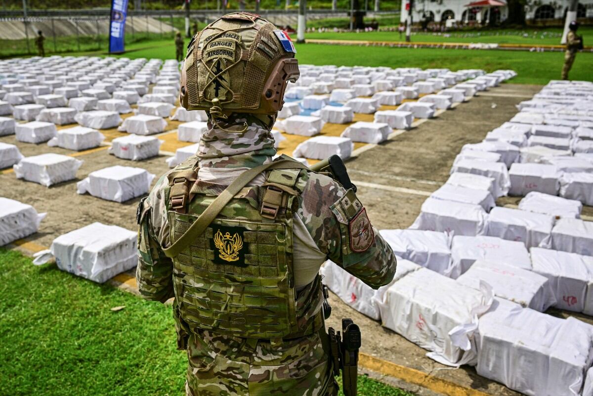 Un oficial del Servicio Aeronaval Nacional de Panamá custodia 12 toneladas de cocaína divididas en cientos de paquetes en la sede de la Aeronaval en Ciudad de Panamá, el 11 de noviembre de 2025. Panamá llevó a cabo una de las mayores incautaciones de droga de su historia tras interceptar cerca de 12 toneladas de cocaína en un buque en el Pacífico con destino a Estados Unidos, según informaron las autoridades locales el 11 de noviembre de 2025. (Foto de Martin BERNETTI / AFP)