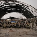 Militares ucranianos gritan consignas patrióticas con el avión Antonov An-225 Mriya destruido durante los combates entre las fuerzas rusas y ucranianas en el aeropuerto Antonov en Hostomel, Ucrania, el sábado 2 de abril de 2022. En la entrada del aeropuerto Antonov en Hostomel, las tropas ucranianas tripulaban sus posiciones, una señal de que tienen el control total de la pista que Rusia intentó asaltar en los primeros días de la guerra. Foto AP/Vadim Ghirda