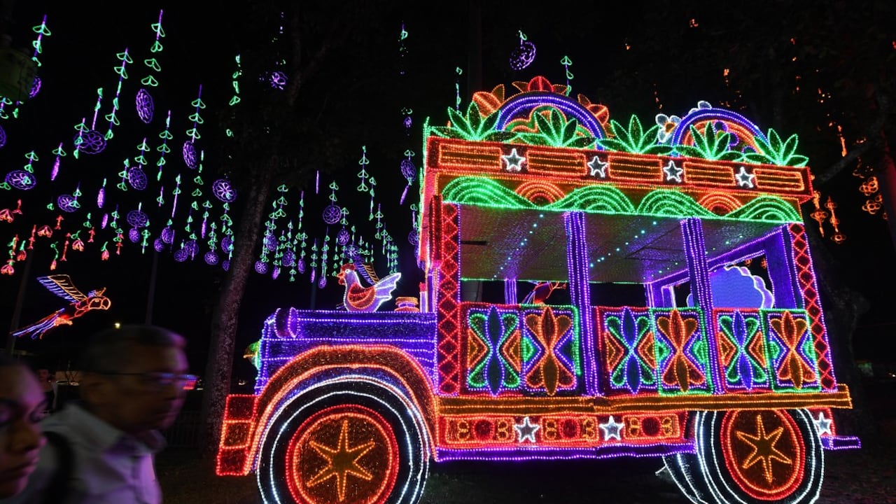 La gente pasa junto a un espectáculo de luces navideñas que representa un autobús chiva en Medellín, Colombia, el 27 de noviembre de 2025. (Foto de Jaime SALDARRIAGA / AFP)