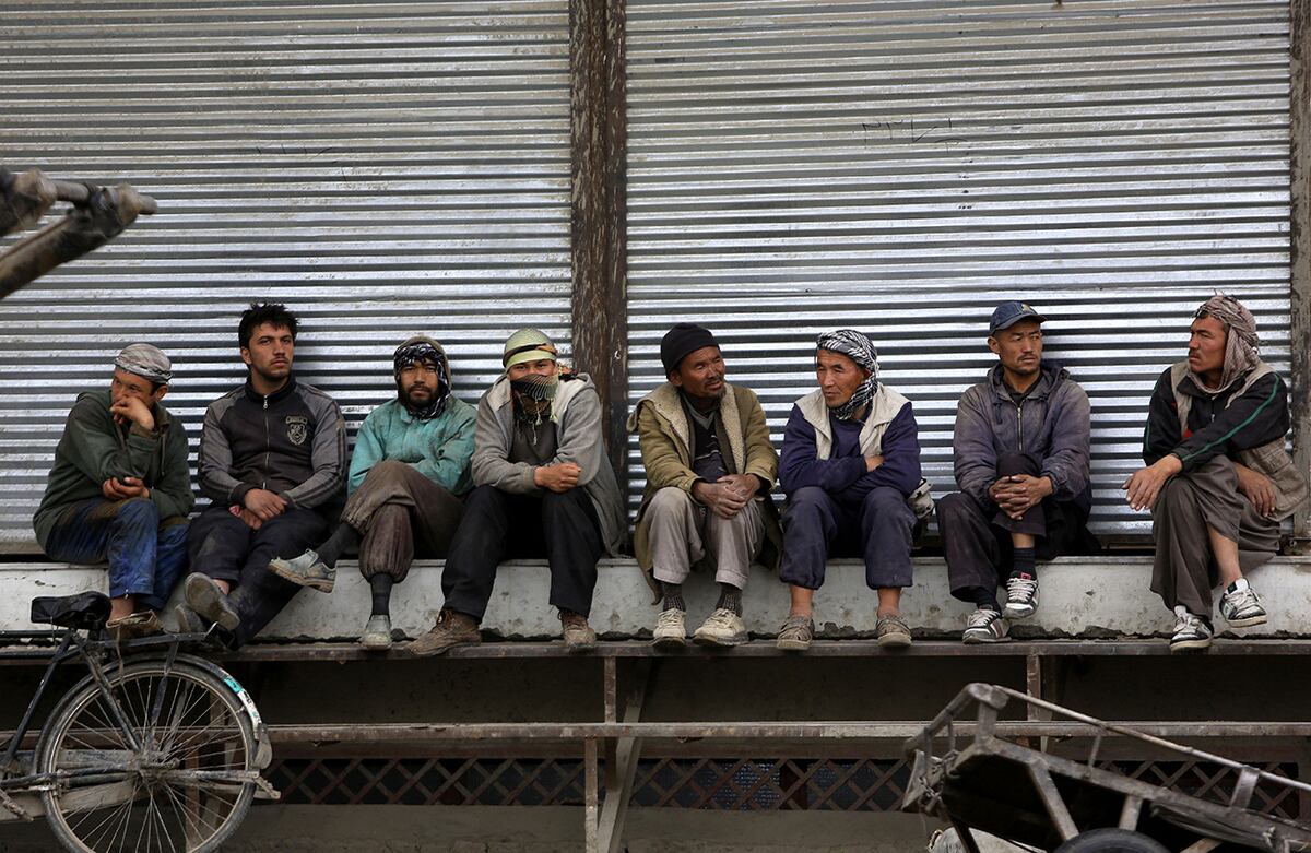 Los trabajadores afganos esperan a sus clientes en Kabúl, Afganistán. (AP)