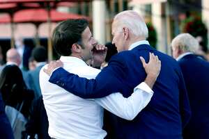 El presidente francés, Emmanuel Macron, le susurra al presidente estadounidense, Joe Biden, luego de su cena en la Cumbre del G7 en Elmau, Alemania, el 26 de junio de 2022. (AP Photo/Susan Walsh, File)