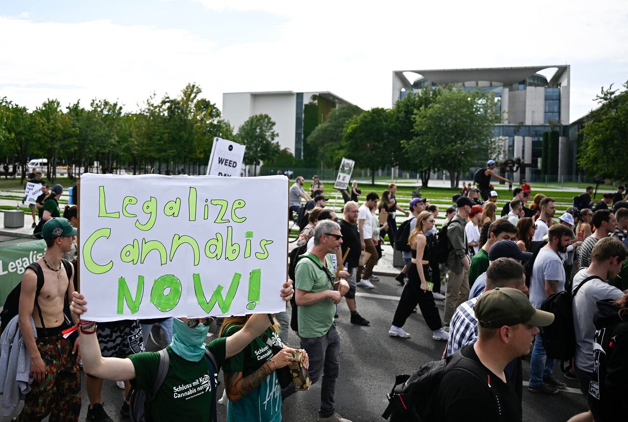 A Participant walks with a sign reading "Legalise Cannabis now" in front of the chancellery during the annual Hemp Parade (Hanfparade), a demonstration for the legalization of hemp, in Berlin's on August 12, 2023. (Photo by Tobias SCHWARZ / AFP)