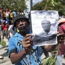 Un manifestante sostiene una foto del oficial de policía, Eddy Derisca, quien murió en la violencia de pandillas, durante una protesta contra la inseguridad en Haití, el lunes 7 de agosto de 2023.