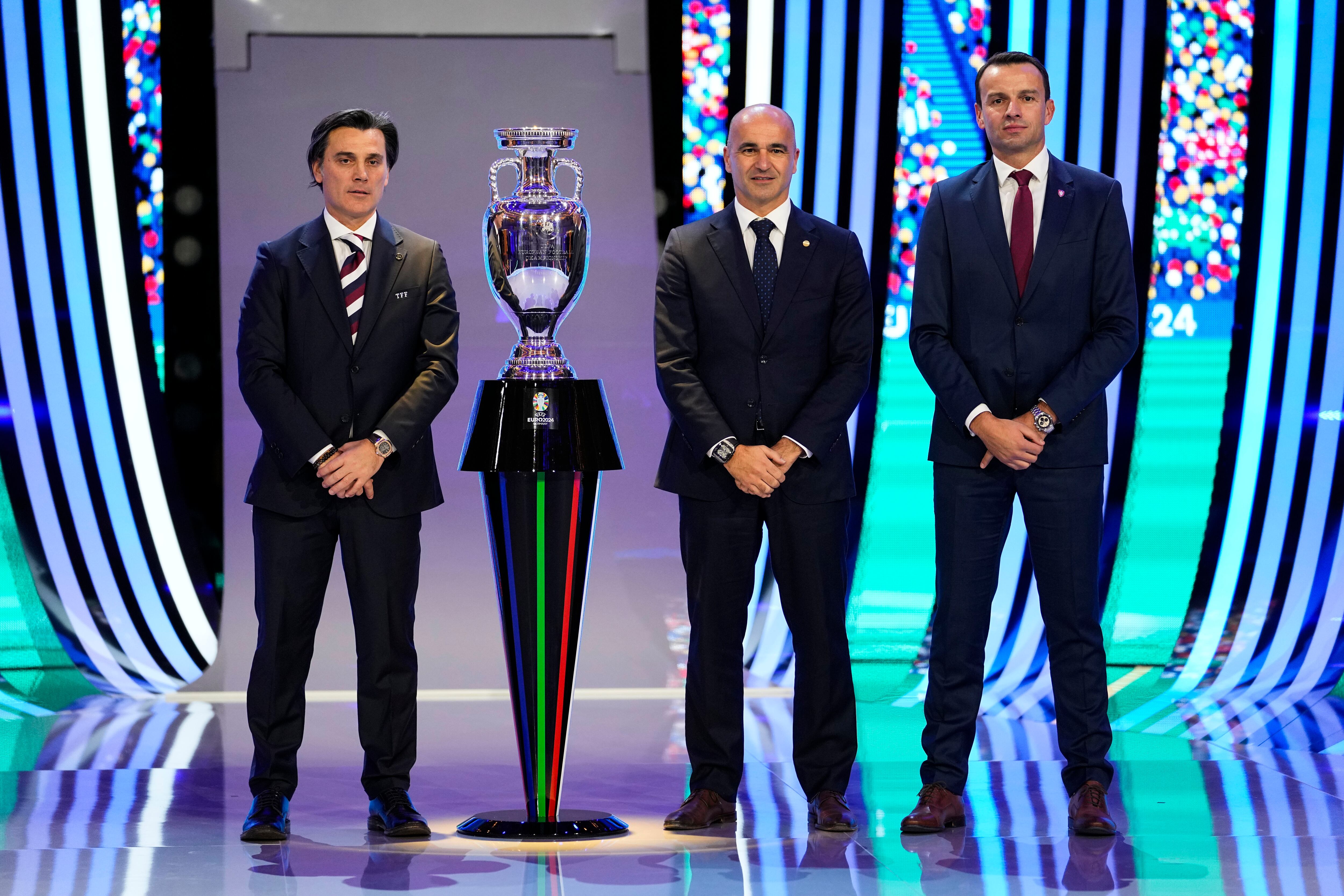 De izquierda a derecha: los entrenadores del grupo F, Vincenzo Montella de Turquía, Roberto Martínez de Portugal y el técnico de la República Checa Erich Brabec posan junto al trofeo después del sorteo de la final del torneo de fútbol UEFA Euro 2024 en Hamburgo, Alemania, el sábado 2 de diciembre de 2023. (Foto AP/Martin Meissner)