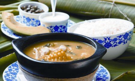 El ajiaco es una sopa caliente que se acompaña con pollo desmenuzado, papas, maíz tierno, guascas, alcaparras, crema de leche y aguacate
