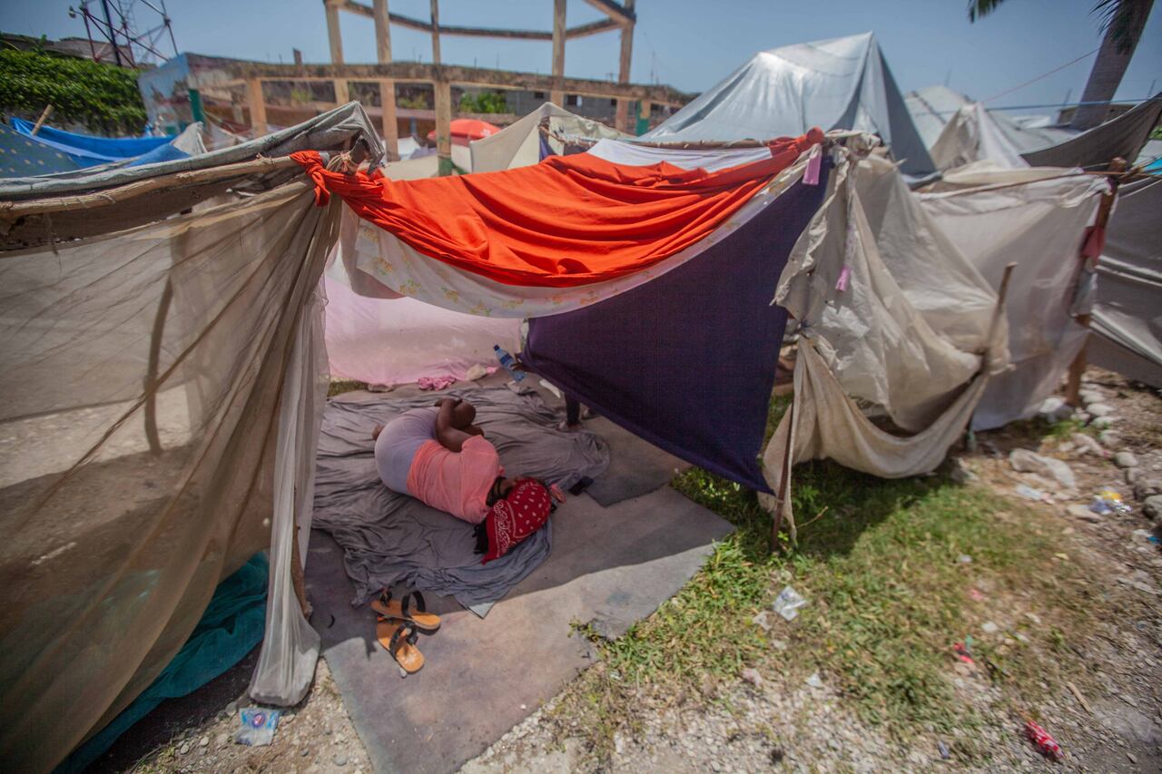 Una mujer descansa en un campamento para personas que perdieron su hogar durante el terremoto del 14 de agosto en Les Cayes, Haití, el 23 de agosto de 2021. - El número de muertos en el gran terremoto que azotó Haití el 14 de agosto ha aumentado a 2.207, dijeron las autoridades. 22 de agosto de 2021, ya que los ataques a los convoyes de ayuda han complicado los esfuerzos para brindar ayuda a los sobrevivientes. (Foto de Richard PIERRIN / AFP)