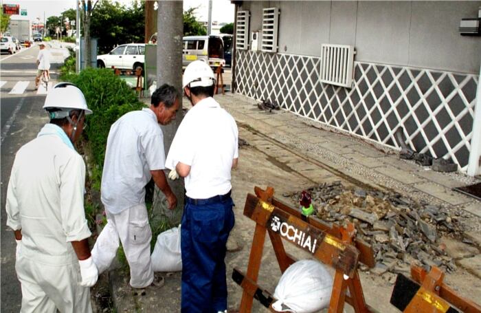 El personal de la ciudad limpia un camino en Makinohara, Japón, después del. 