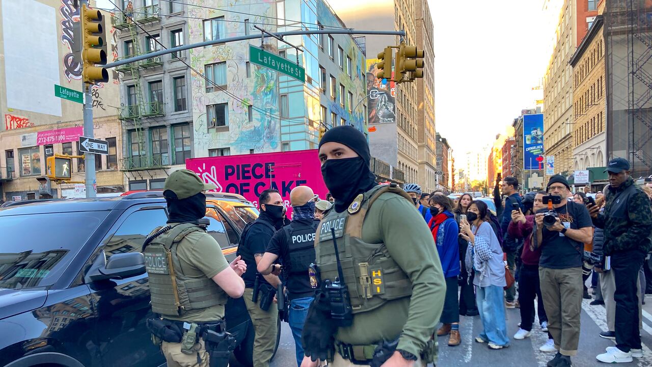 Agentes federales realizan una redada migratoria en Canal Street, Manhattan, mientras varios manifestantes se reúnen.