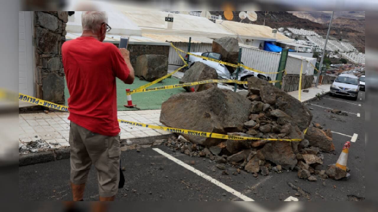Un hombre fotografía un vehículo que es aplastado por una gran roca a consecuencia de la tormenta tropical Hermine, en España. -Foto: Reuters. / Autor: Borja Suárez.
