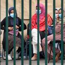 Los jóvenes se sientan detrás de una cerca en la base aérea de Ramstein Us, en Ramstein, Alemania, lunes, 30 de agosto, 2021. La comunidad militar estadounidense más grande en el extranjero alberga miles de evacuados afganos en una ciudad de TENT en la barra aérea. (AP Foto / Matthias Schrader)