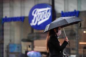 Una mujer camina bajo su sombrilla por la fuerte lluvia mientras que camina en Piccadilly Circus. Foto: Aaron Chown / PA vía AP