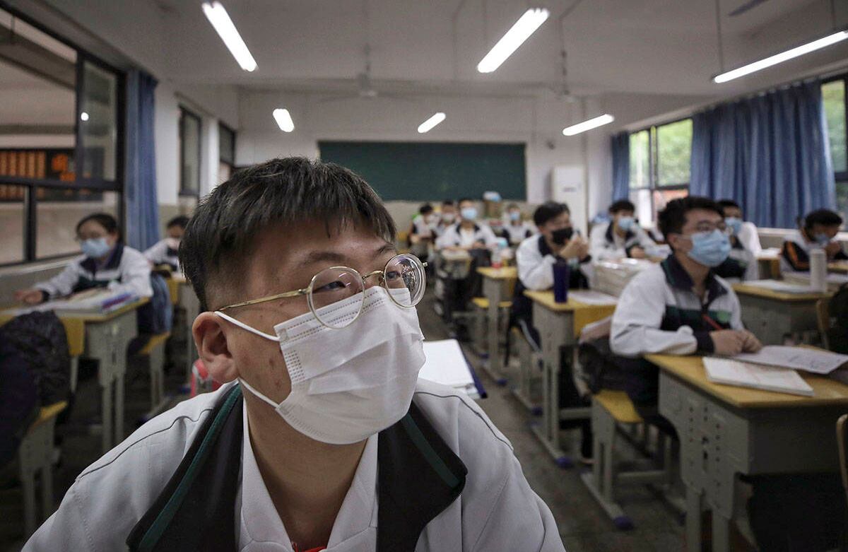 Los estudiantes asisten a una clase en una escuela secundaria en Wuhan, en la provincia central china de Hubei, el miércoles 6 de mayo de 2020. Todos usando tapabocas. Andy Wong / AP