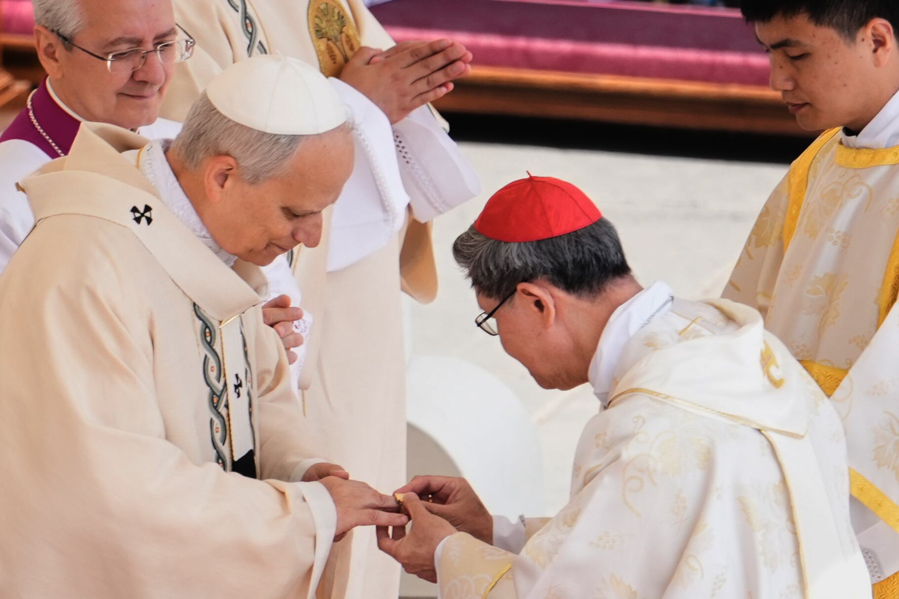 El cardenal Luis Antonio Tagle (2.ª der.) coloca el Anillo del Pescador en el dedo del Papa León XIV durante la misa de inauguración oficial de su pontificado, celebrada el 18 de mayo de 2025 en la Ciudad del Vaticano.