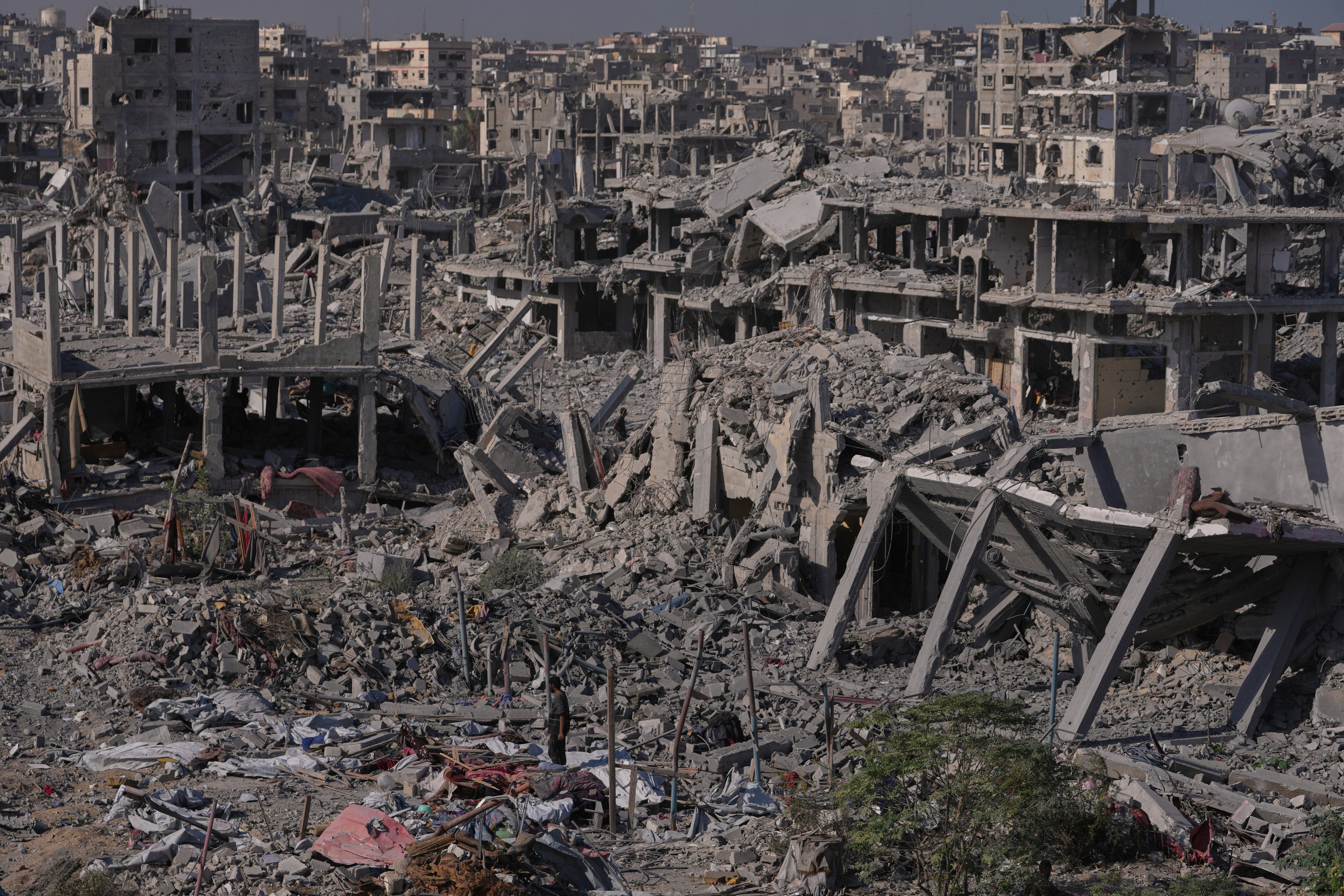 Palestinos desplazados inspeccionan una zona rodeada de edificios destruidos en Khan Younis, en el sur de la Franja de Gaza.