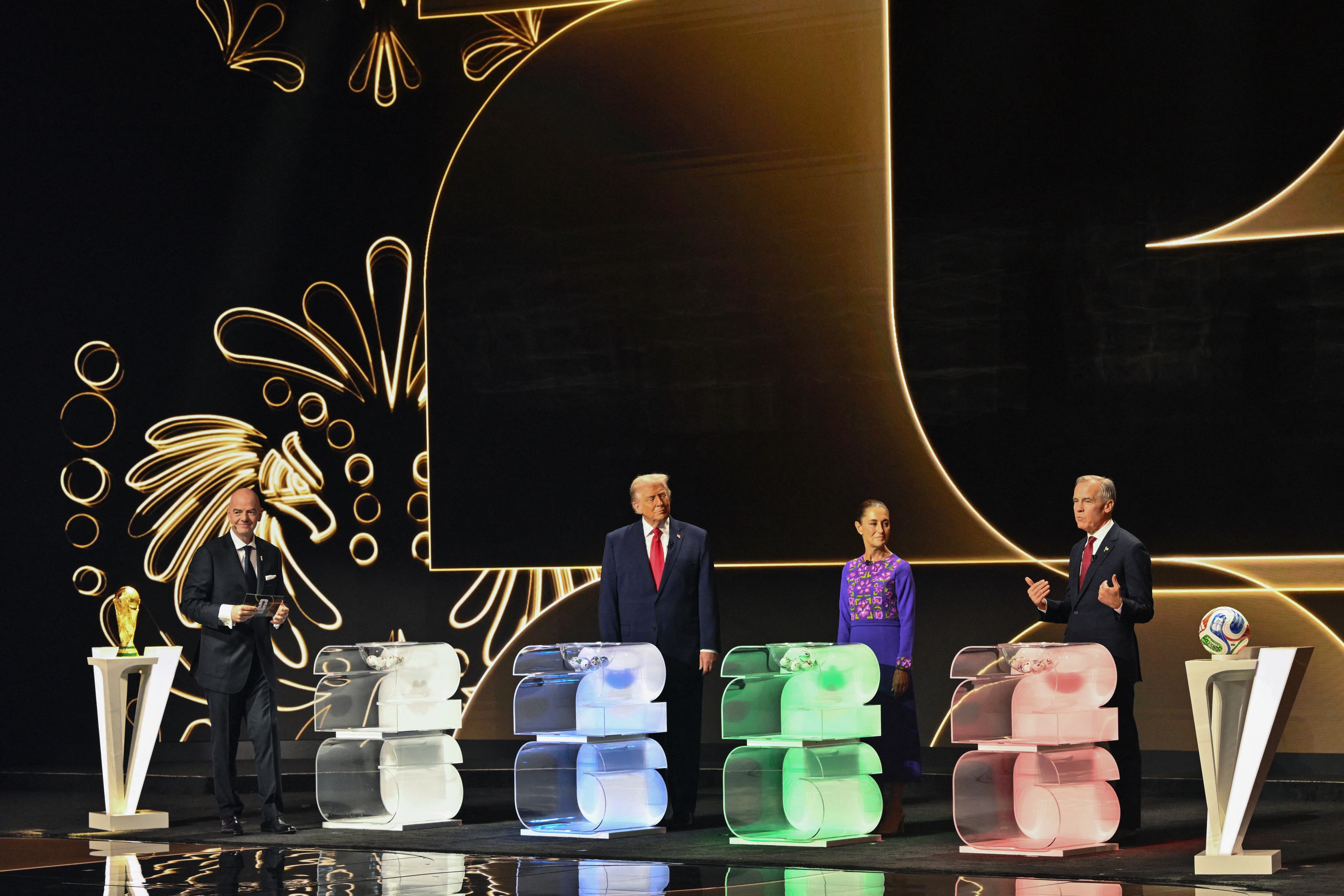 (L/R) FIFA President Gianni Infantino, US President Donald Trump, Mexico's President Claudia Sheinbaum, and Canada's Prime Minister Mark Carney stand on stage during the draw for the 2026 FIFA Football World Cup taking place in the US, Canada and Mexico, at the Kennedy Center, in Washington, DC, on December 5, 2025. (Photo by Mandel NGAN / POOL / AFP)
