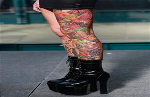 Cualquier parte del cuerpo es válida para tatuar. Esta visitante expone el diseño de sus piernas