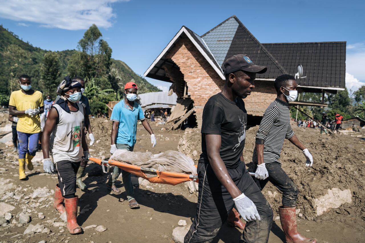 Los residentes de Nyamukubi cargan un cuerpo entre los escombros después de las fuertes inundaciones en el este de la República Democrática del Congo