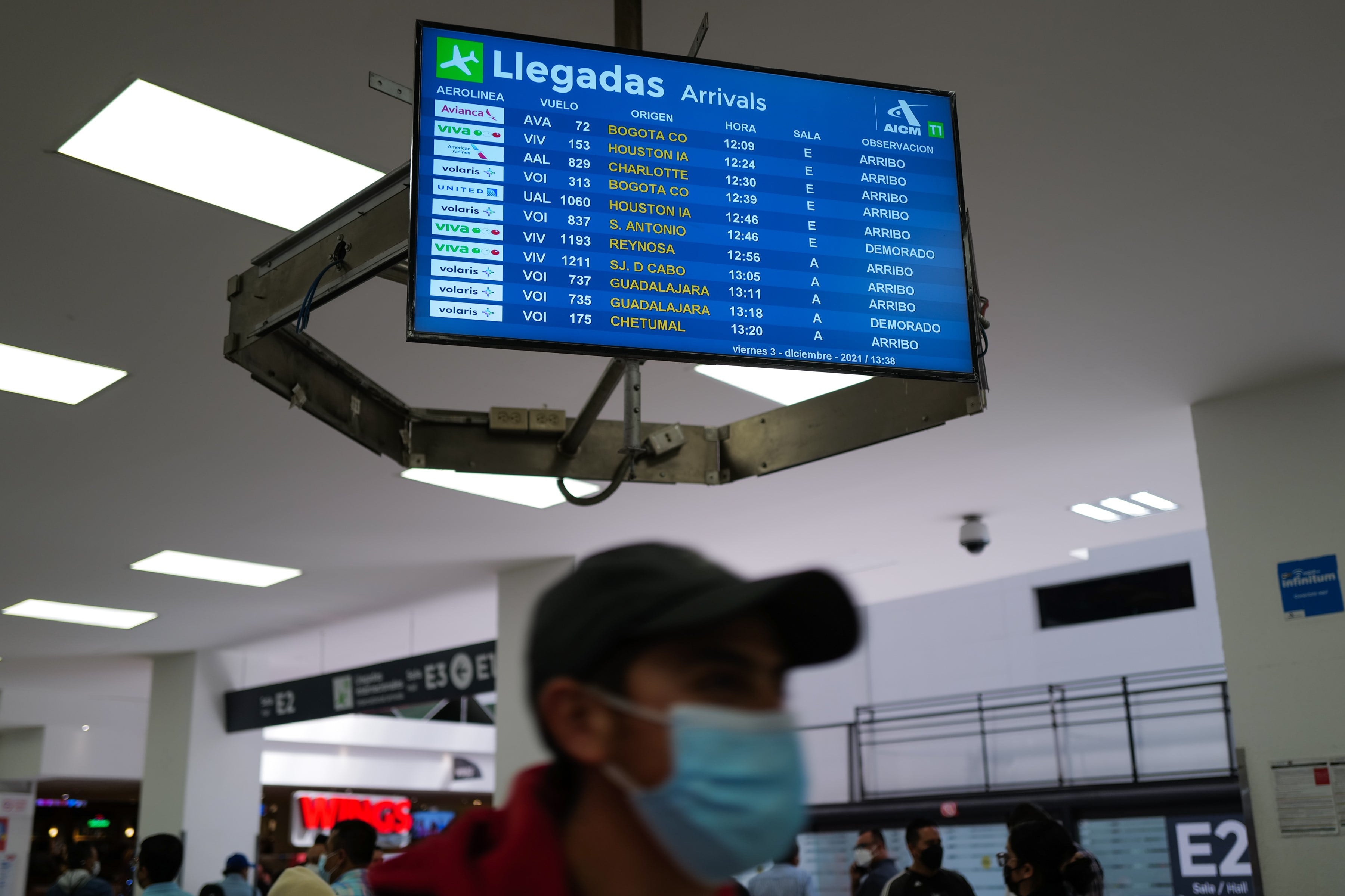 Una pantalla muestra las salidas y llegadas de vuelos en el aeropuerto Internacional de México
