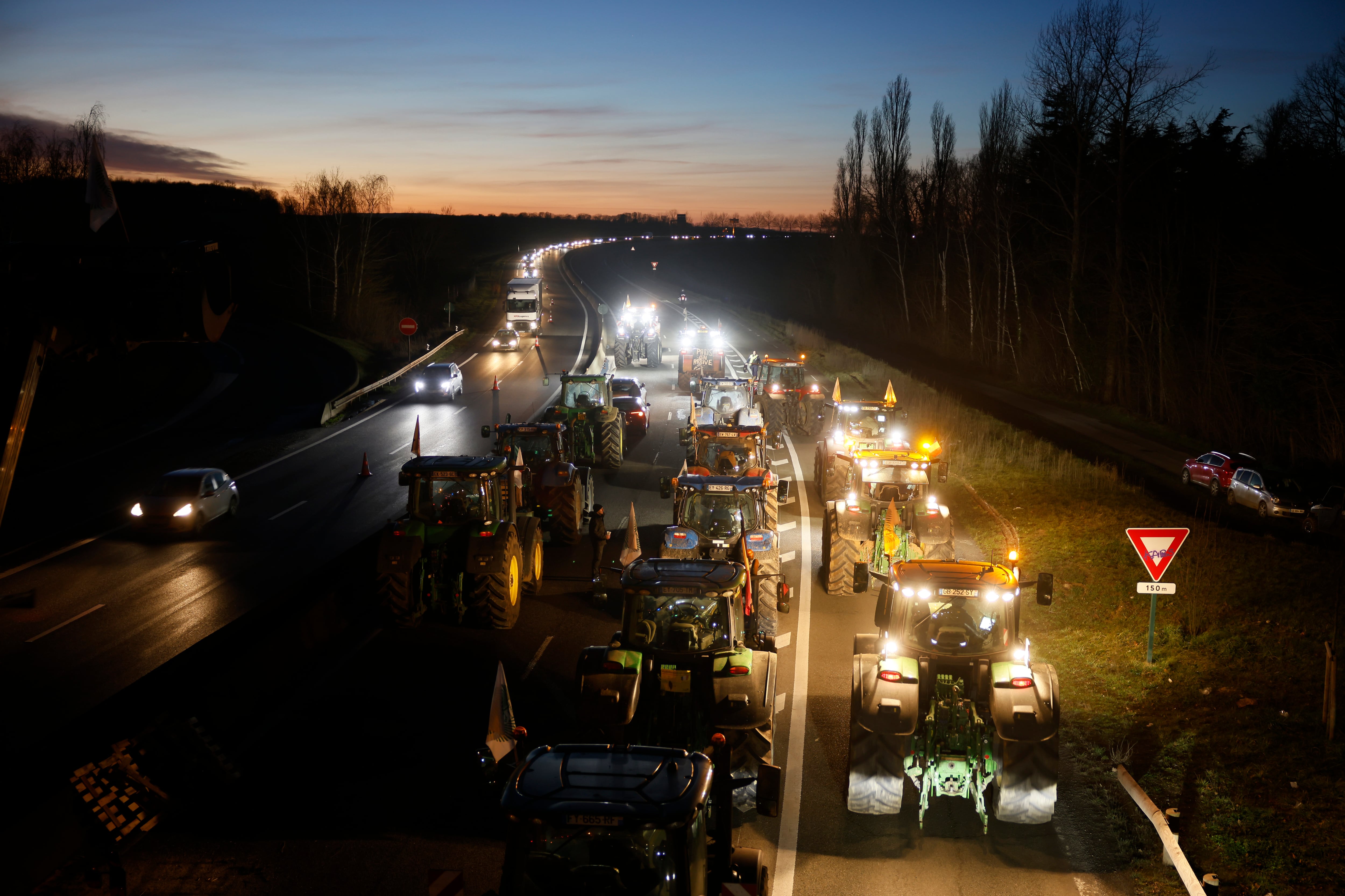 Los agricultores bloquean una carretera cerca de Ableiges, al norte de París, el viernes 26 de enero de 2024. Los agricultores que protestaban cerraron largos tramos de algunas de las principales autopistas de Francia el viernes, utilizando sus tractores para bloquear y ralentizar el tráfico y presionar al gobierno cada vez más para ceder a sus demandas de que el cultivo y la cría de alimentos sean más fáciles y lucrativos.