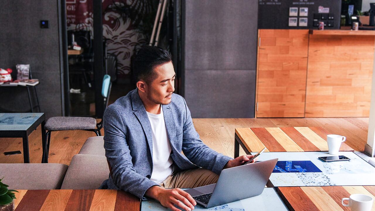 Hombre de negocios asiático trabajando solo sentado en un espacio de coworking