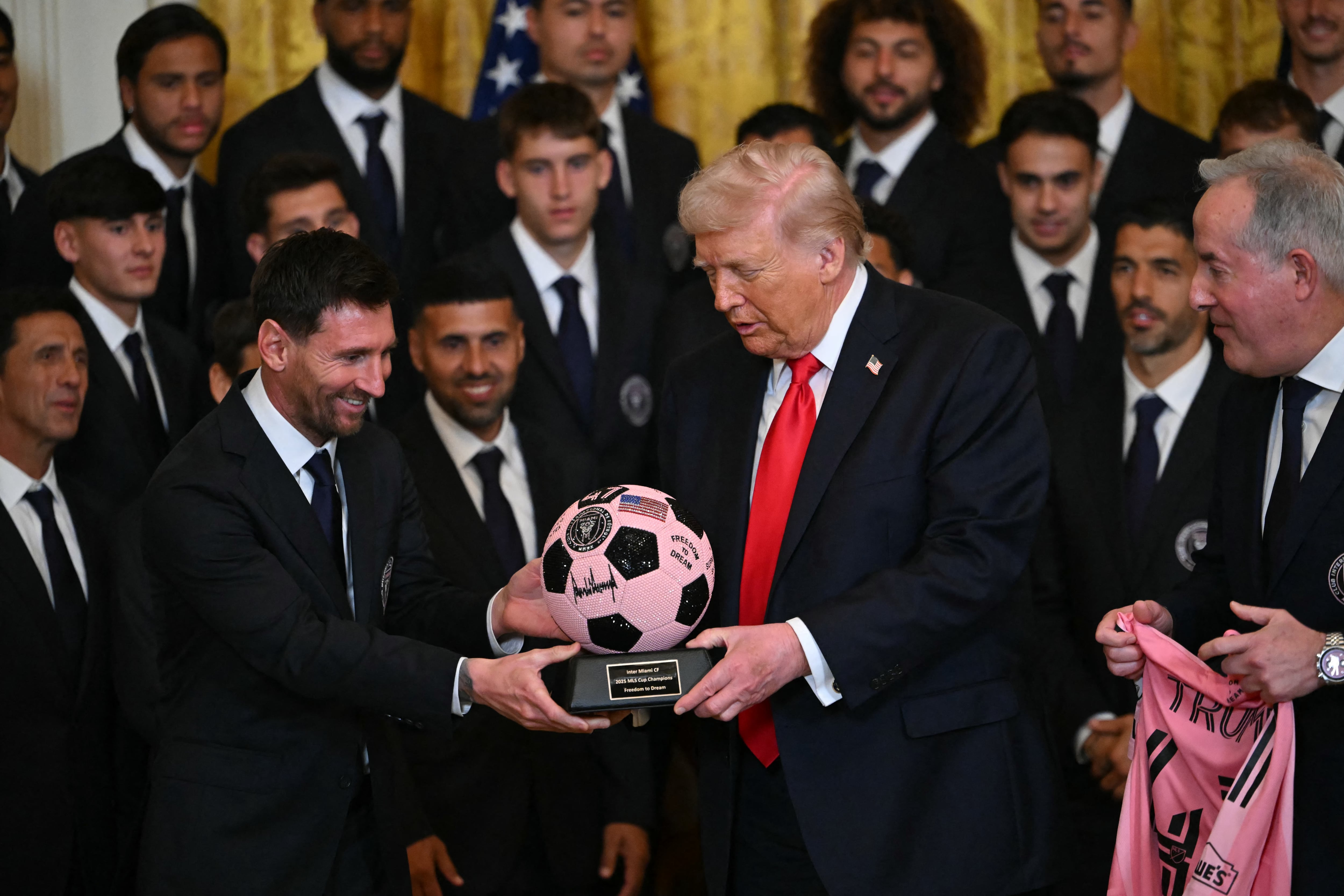 El delantero argentino del Inter Miami, Lionel Messi, entrega al presidente de Estados Unidos, Donald Trump, un balón trofeo durante un evento en honor al Inter Miami CF, ganador de la Copa de la Major League Soccer 2025, en el Salón Este de la Casa Blanca en Washington, DC, el 5 de marzo de 2026. (Foto de ANDREW CABALLERO-REYNOLDS / AFP)